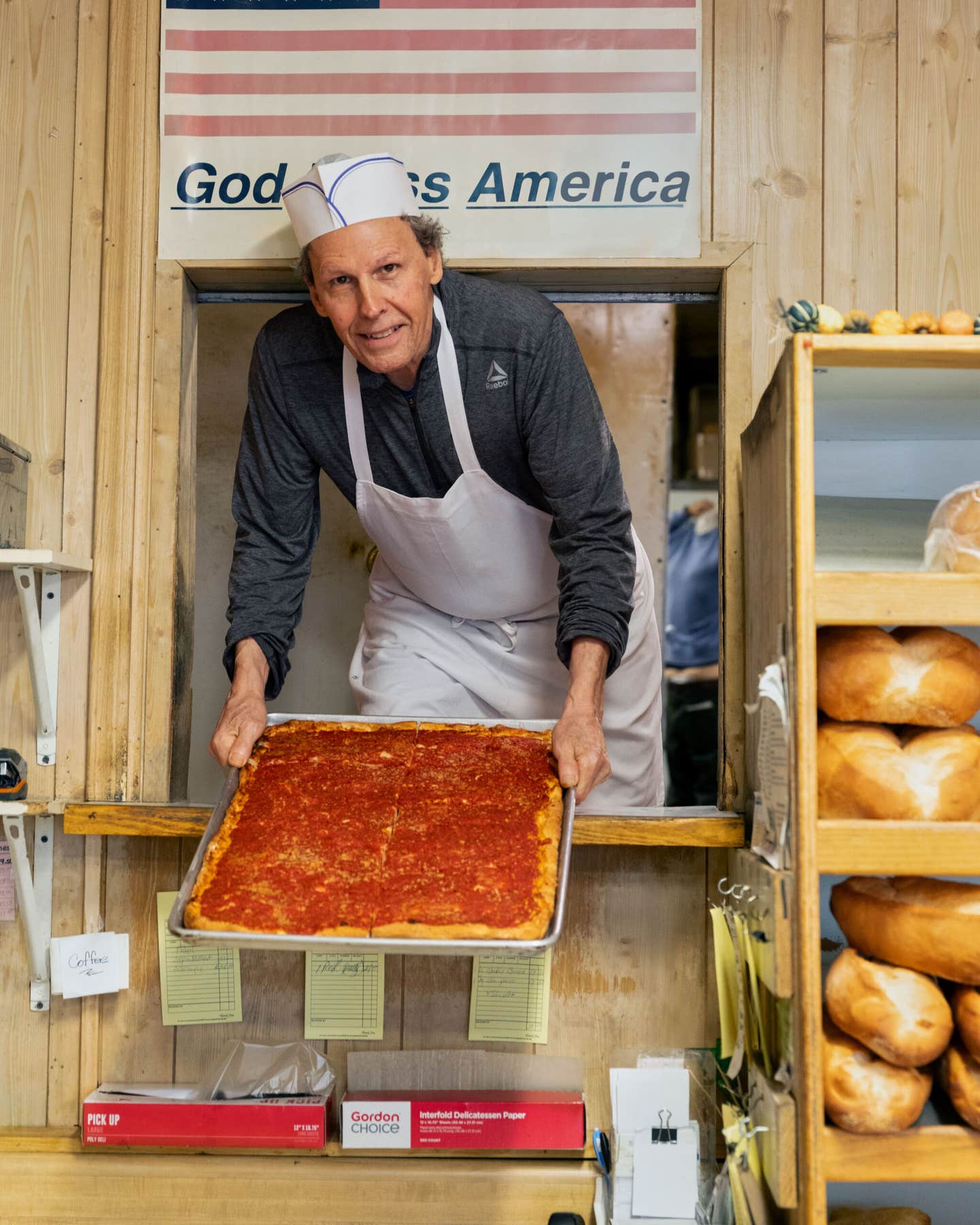 Baker Robert Savastano presents a sheet of cooled pizza strips at Sal’s Bakery in Providence